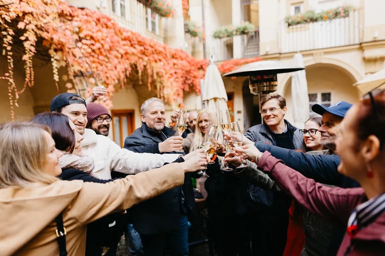 Members of the community raising a toast together in a sunlit courtyard