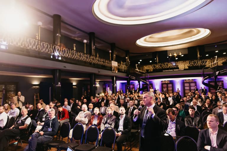 An attendee standing to ask a question in the conference hall