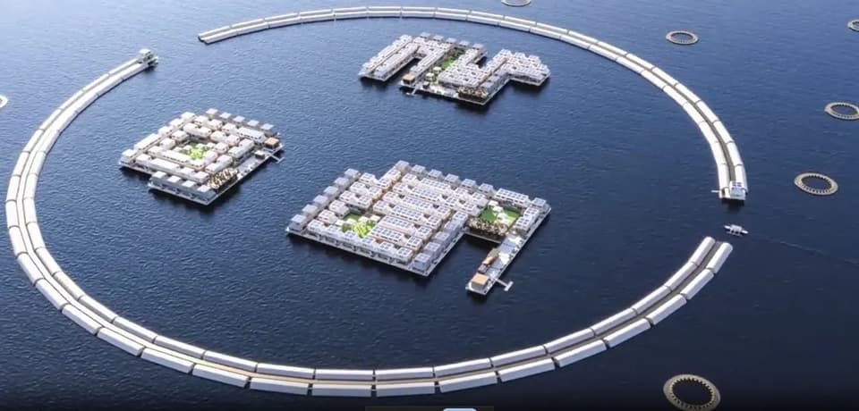 Rendering of ArkPad’s floating city: blocks of housing inside a circular breakwater, with fish pens around the outside