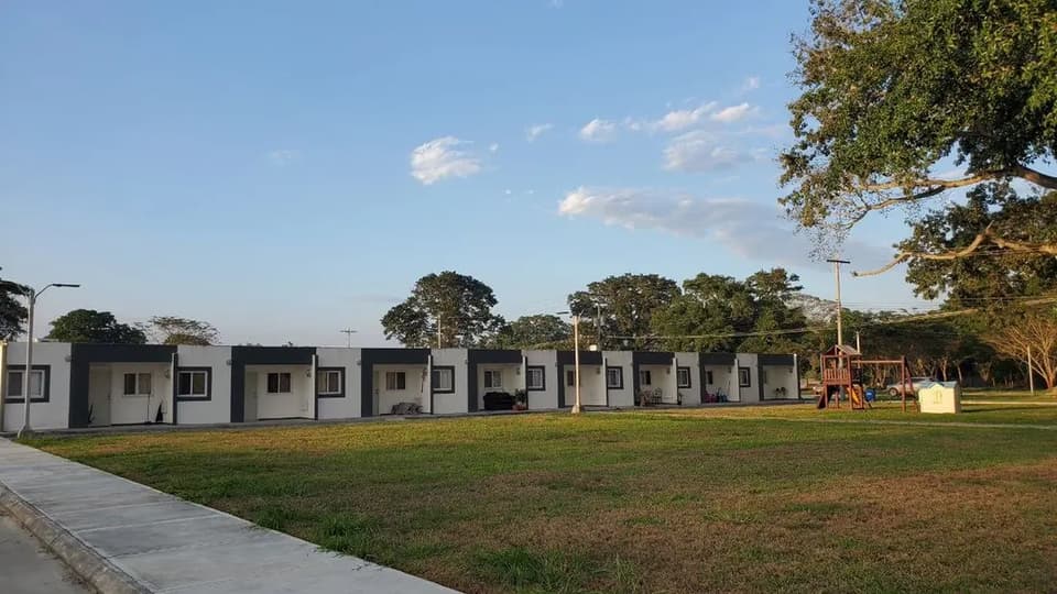 A row of completed homes along a green at Ciudad Morazán