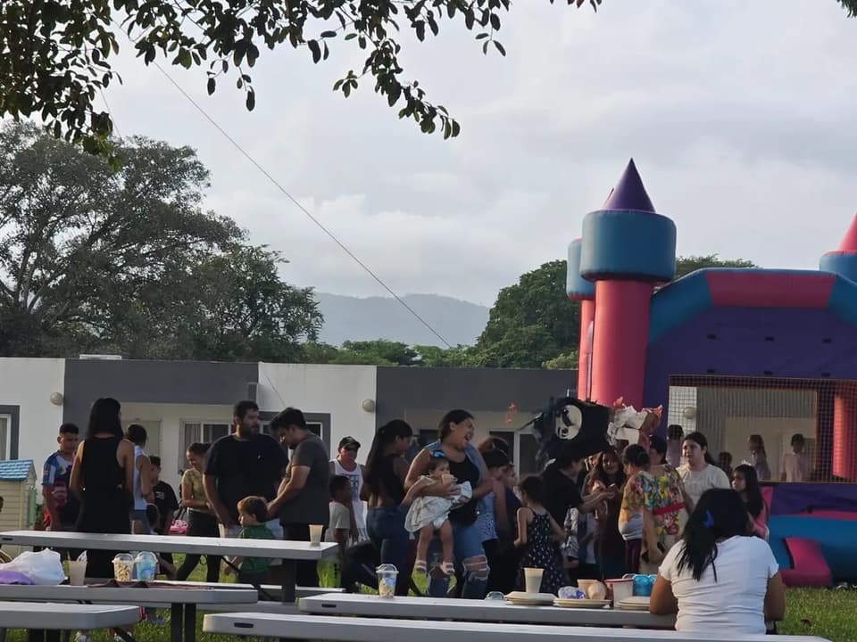 Families at a community event with a bouncy castle at Ciudad Morazán