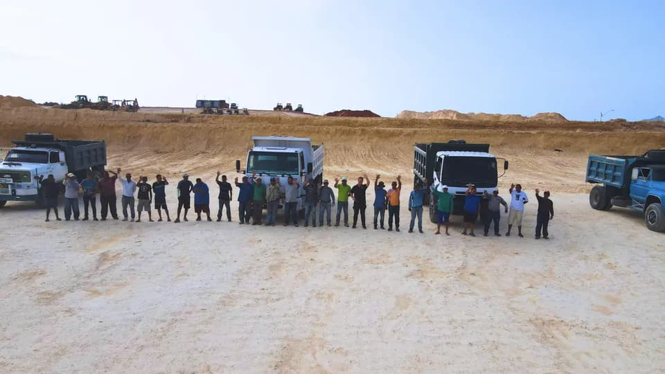 The earthworks crew lined up with their tipper trucks in the cutting, arms raised