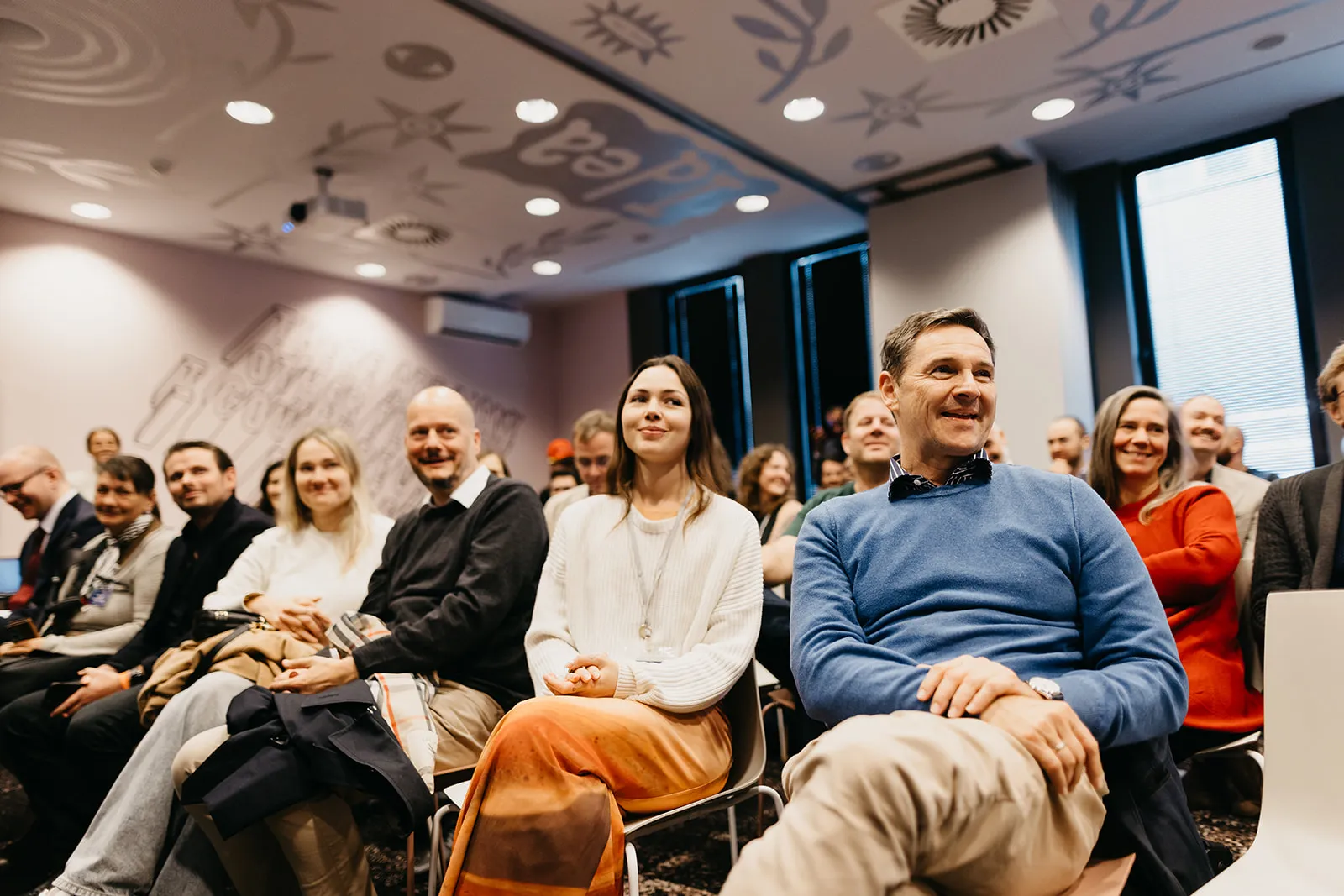 Attendees smiling as they listen to a talk at the Free Cities Conference