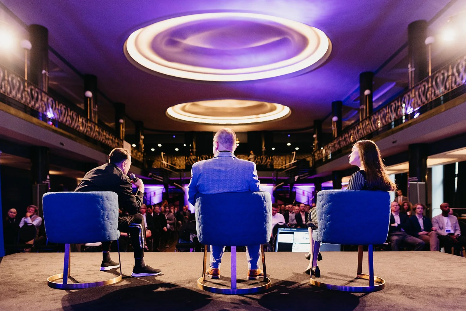 Three speakers on stage during a panel discussion at the conference