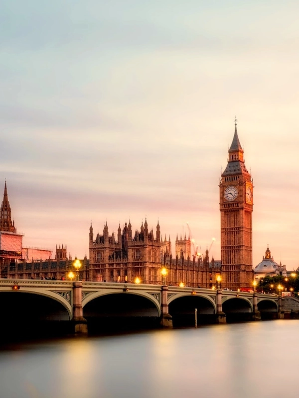 Big Ben and the Houses of Parliament beside Westminster Bridge at dusk