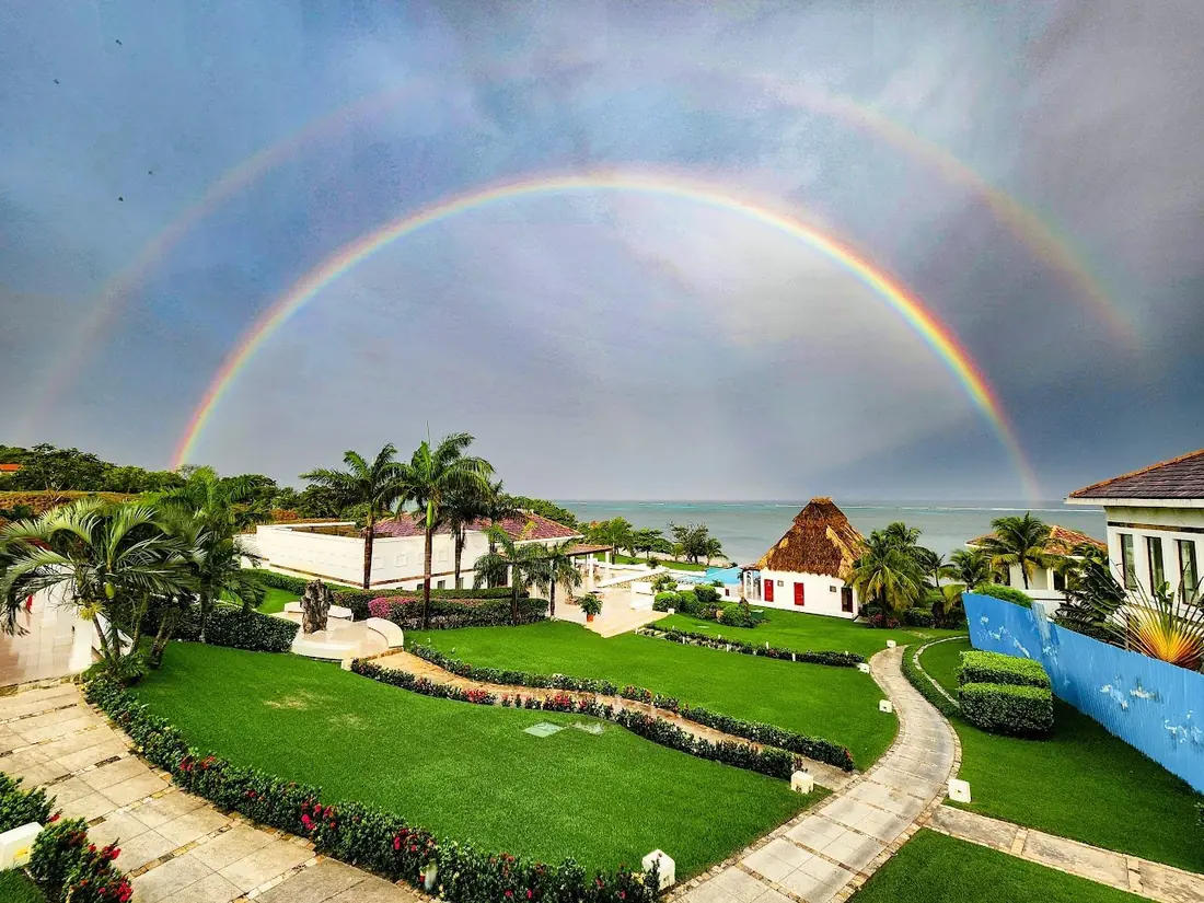 A rainbow over the gardens and coastline at Próspera, Roatán