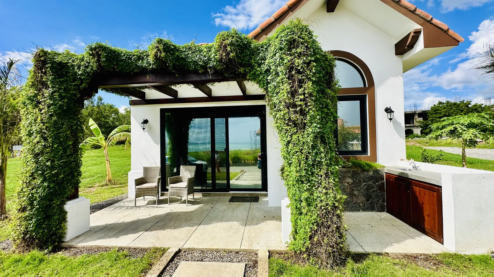 A white-walled home with a red tile roof at Veritas Village Playa Pacifica, Nicaragua
